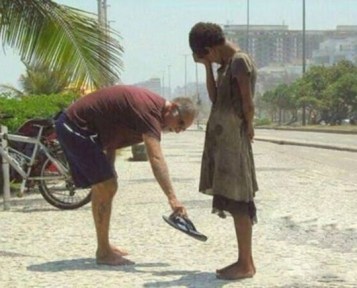 A-man-giving-a-homeless-woman-his-shoes